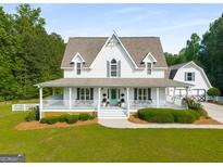 Charming two-story home with a welcoming porch and well-manicured lawn at 692 Brooks Woolsey Rd, Brooks, GA 30205