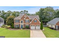 Charming brick two-story home with a well-manicured lawn and lovely landscaping at 960 Pebblestone Ct, Alpharetta, GA 30009