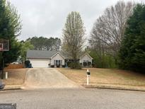 Charming one-story home with a well-maintained lawn, concrete driveway, and inviting curb appeal at 123 Chippewa Run, Auburn, GA 30011