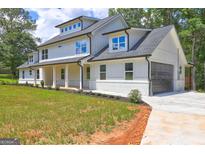 Stunning two-story home with a modern design, lush green lawn, and attached garage at 375 Foster Dr, Mcdonough, GA 30253