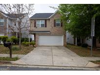 Charming two-story home with a brick and beige exterior, integrated garage, and a concrete driveway at 1579 Leonard St, Hampton, GA 30228