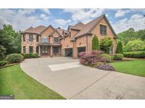 Beautiful two-story brick home featuring a large driveway and well-maintained landscaping at 4818 Moon Hollow Ct, Buford, GA 30519