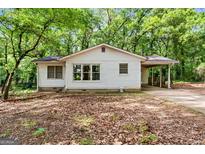 Charming single-story home with a covered parking area surrounded by mature trees at 397 Campground Rd, Mcdonough, GA 30253
