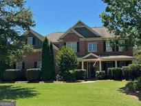 Charming two-story brick home with a well-manicured lawn and a welcoming front porch at 910 Ovalene Sw Ln, Marietta, GA 30064