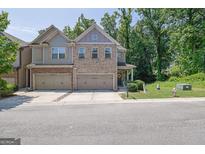 Charming two-story townhome showcasing brick and siding accents, a well-manicured lawn, and attached two-car garage at 2333 White Oak Se Bnd, Smyrna, GA 30080