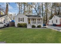 Charming single-story home with a well-maintained lawn and inviting front porch with white railings at 2912 Palm, East Point, GA 30344