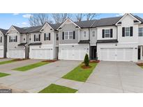 Modern townhome exteriors featuring attached garages and landscaped front lawns at 310 Sound Circle, Stockbridge, GA 30281