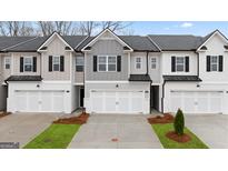 Charming townhome showcasing a modern exterior with attached garages and well-manicured landscaping at 314 Sound Cir, Stockbridge, GA 30281