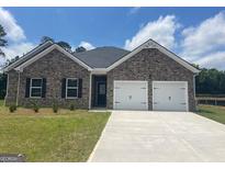 Charming single-story home featuring a brick facade, two-car garage, and well-manicured lawn at 1676 Fuma Leaf Way # 305, Mcdonough, GA 30253
