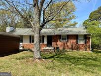 Charming single-story brick home with a well-maintained front yard and mature shade trees at 107 Woodhaven Dr, Stockbridge, GA 30281