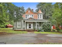 Charming two-story home with a welcoming front porch and a well-manicured lawn and beautiful accent turrets at 435 Jackson St, Locust Grove, GA 30248