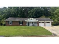 Charming brick home with attached two car garage, black shutters, and white trim at 3857 Pointers Sw Way, Conyers, GA 30094