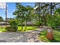 Charming ranch home with mature trees, lush lawn, and a long driveway leading to the house at 315 Burke Cir, Mcdonough, GA 30253