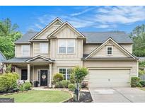 Charming two-story home with a well-manicured lawn, beautiful landscaping and a two car garage at 230 Haleys Ct, Woodstock, GA 30188
