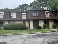 Modest townhouse with brown shingles and manicured shrubbery at 2968 Par Lorraine, Lithonia, GA 30038