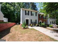 Charming two-story townhome featuring a well-maintained front yard and a private driveway at 1346 Revelstoke Cv, Riverdale, GA 30296