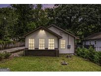 Charming bungalow featuring a well-manicured lawn and three windows that enhance the facade at 523 Mount Zion, Hapeville, GA 30354