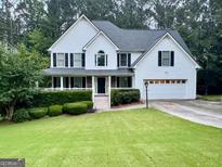 Charming two-story home with a well-manicured lawn, attached garage, and lovely landscaping at 111 Bexley Ln, Douglasville, GA 30134