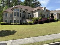 Beautiful two-story home boasting well-manicured lawn, brick facade, and lush landscaping at 2360 Barrington Trace Sw Cir, South Fulton, GA 30331