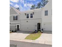 Charming townhome with a two-car garage, brick accents, and manicured lawn and welcome sign at 3349 Verdi Ln, Kennesaw, GA 30144