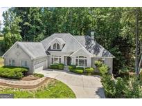 Stunning single-Gathering home with a well-manicured front yard, lush landscaping, and a circular driveway at 3600 Goldenrod Dr, Alpharetta, GA 30005