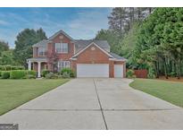 Charming two-story brick home with a well-manicured lawn and long driveway at 500 Merrill Ln, Peachtree City, GA 30269
