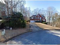 Charming two-story brick home with a well-manicured lawn and a two-car garage on a sunny day at 1850 Noblin Ridge Way, Duluth, GA 30097