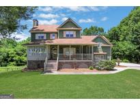 Inviting two-story home with a charming front porch and well-manicured lawn at 940 Planters Pl, Loganville, GA 30052
