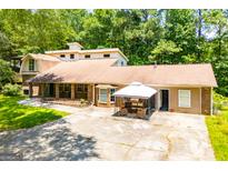 Sprawling tan and brick home with multiple entrances, large front yard and lots of parking at 258 Big Oak Rd, Whitesburg, GA 30185