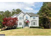 Beautiful two-story home with manicured lawn and a charming American flag display at 165 Longshore Way, Fayetteville, GA 30215