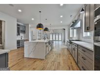 Spacious kitchen featuring a large island, stainless steel appliances, and modern lighting fixtures at 1240 Hayes Sq, Peachtree City, GA 30269