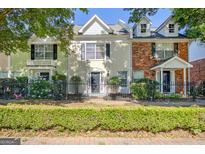 Charming townhome with well-maintained landscaping, dark shutters and a cozy, gated front yard at 488 N Jeff Davis Dr, Fayetteville, GA 30214