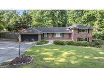 Charming single Gathering home with manicured front lawn and brick facade, nestled in a lush, green neighborhood at 23 Hunting Creek Dr, Marietta, GA 30068