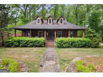 Charming home featuring a cozy front porch, dormer windows, and a well-maintained lawn at 68 Edwin Pl, Atlanta, GA 30318