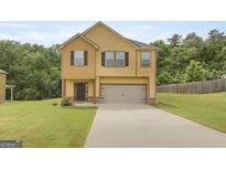 Inviting two-story home with a neutral color scheme, a two-car garage, and a well-manicured lawn at 340 Mcgiboney Ln, Covington, GA 30016