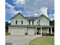 Two-story home with light-blue siding, black shutters, three-car garage, and well-maintained landscaping at 9108 Alden Dr, Locust Grove, GA 30248