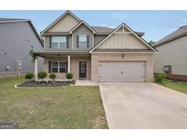 Charming two-story home features a brick facade, two-car garage, and well-manicured lawn at 9046 Holder Rd, Locust Grove, GA 30248