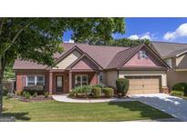 Charming single-story home with manicured lawn, brick accents, and attached two-car garage at 474 Strawberry Walk, Loganville, GA 30052