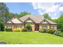 Charming brick and stone home featuring a manicured lawn and well-maintained landscaping, creating inviting curb appeal at 799 Wagon Trail Trl, Woodstock, GA 30188