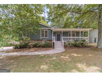 Charming home with a covered front porch, well-maintained landscaping and mature trees at 3404 Broxton Mill Way, Snellville, GA 30039