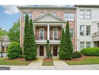 Beautiful brick townhome with a cozy balcony and manicured landscaping for a welcoming curb appeal at 1858 Preserve Way, Atlanta, GA 30341