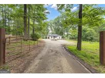 Secluded home featuring mature landscaping and a long driveway at 6290 Cascade Palmetto Hwy, Fairburn, GA 30213