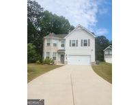 Charming two-story home with a two-car garage, light brick accents, and a well-manicured lawn at 1049 Homer Ln, Stockbridge, GA 30281