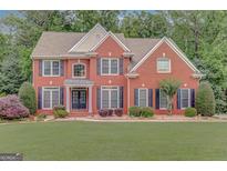 Charming two-story red brick home with black shutters and manicured lawn at 165 Hidden Lake Dr, Fayetteville, GA 30215