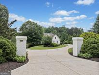 Inviting circular driveway leading to a charming home with lush landscaping at 590 Arthur Rd, Canton, GA 30115