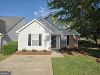 Charming single-Gathering home with light siding, black shutters, manicured lawn and mature tree in a quiet neighborhood at 3075 Lakeside Cir, Covington, GA 30016