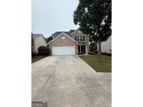 Charming two-story brick home with a two-car garage and mature landscaping at 921 Winding Down, Grayson, GA 30017