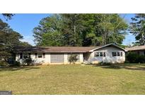 Charming single-story home with a well-maintained lawn and decorative lattice feature at 503 Roy Huie Rd, Riverdale, GA 30274