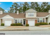 Inviting townhouse with a manicured lawn, attached garage, and partial brick facade at 124 Camry Sw Ln, Grayson, GA 30017