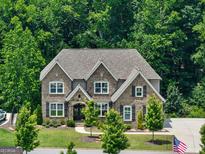 Stunning two-story brick home featuring a meticulously landscaped front yard, a welcoming entrance, and charming black shutters at 3525 Montebello Pkwy, Cumming, GA 30028
